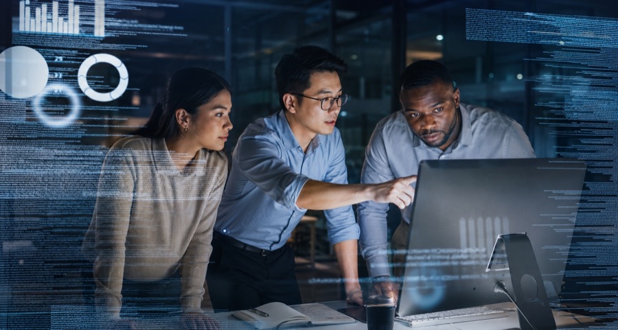 Three people reviewing software together at a computer